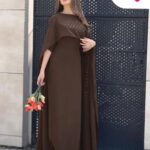 A woman in a long brown gown with a matching draped shawl holding tulips.