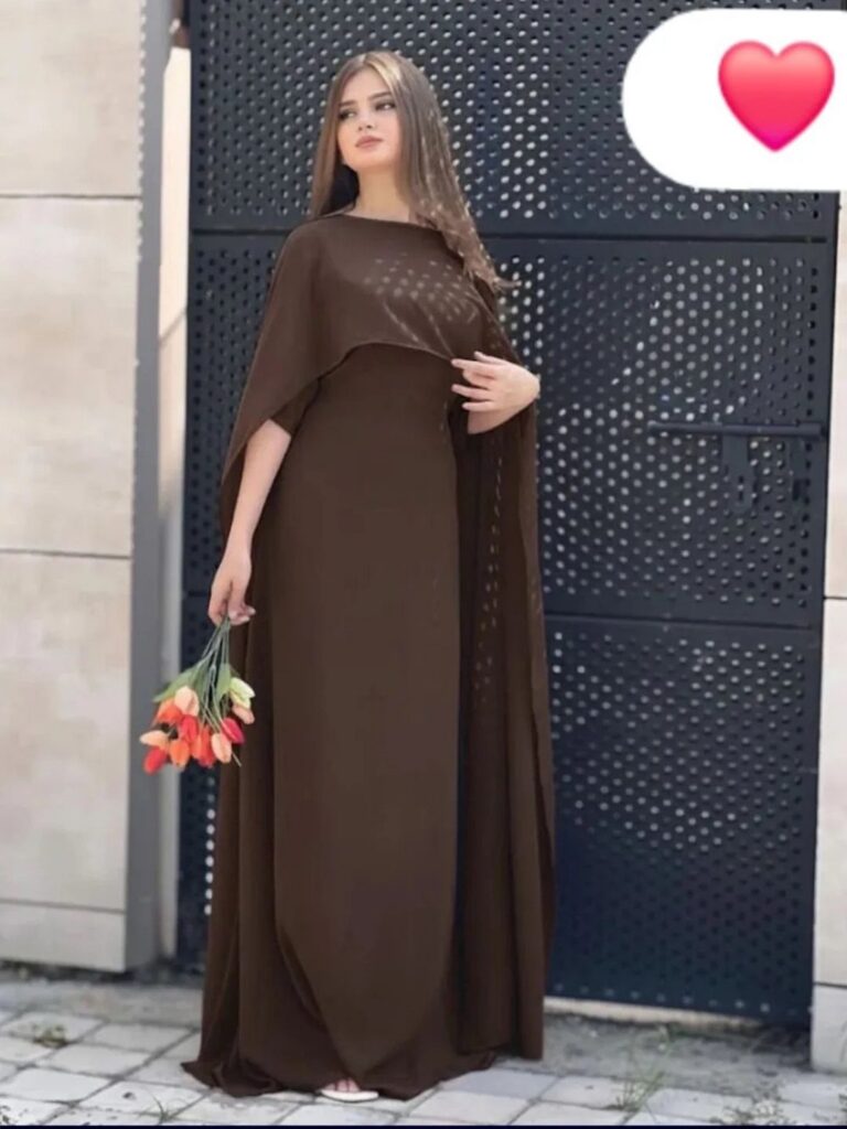A woman in a long brown gown with a matching draped shawl holding tulips.