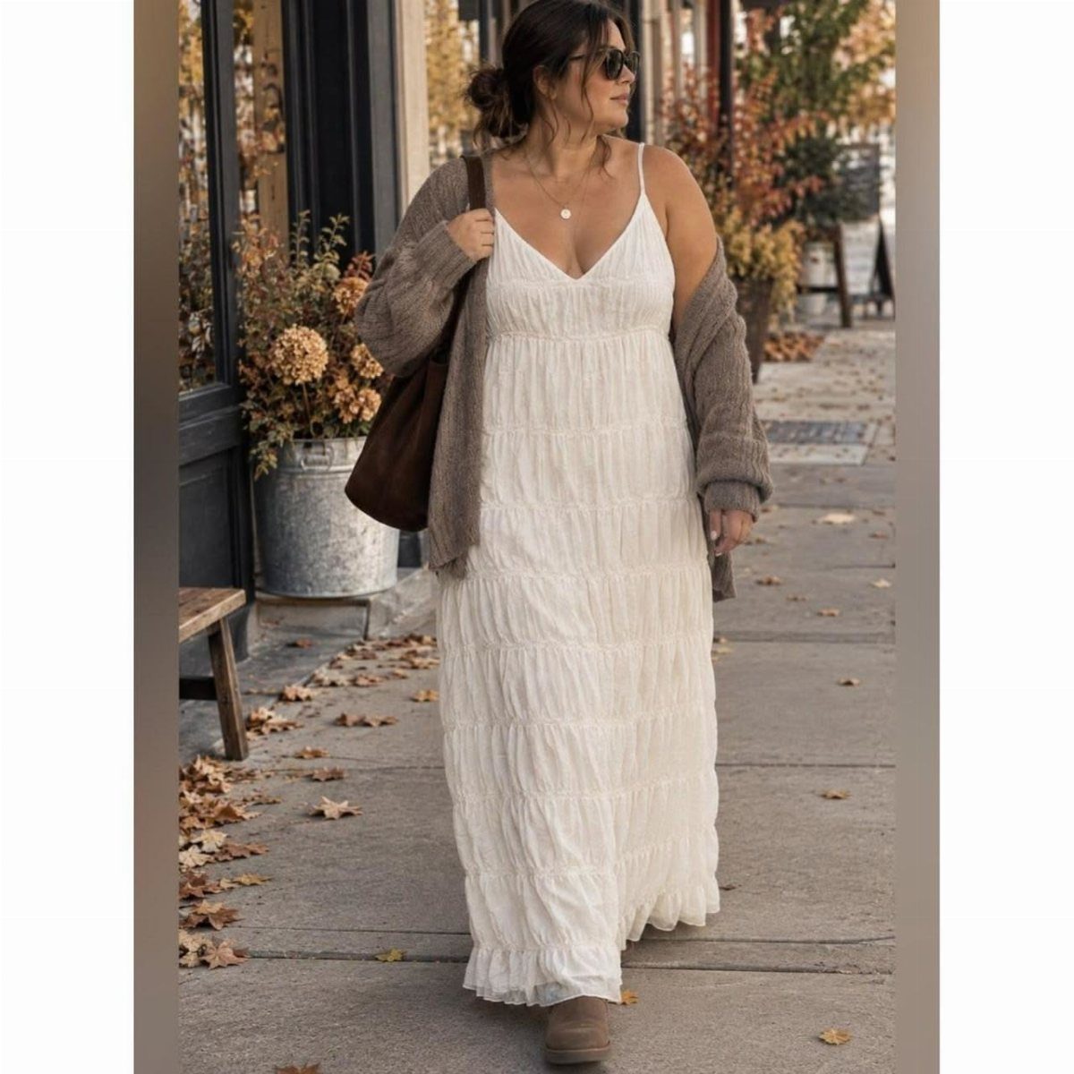 Woman walking outdoors wearing a white tiered maxi dress and a long grey cardigan.